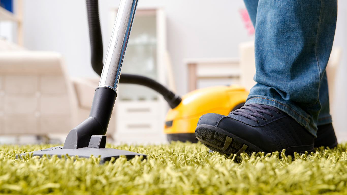 Brown carpet with grid pattern in a room with bed and cabinet, lit by sunlight.