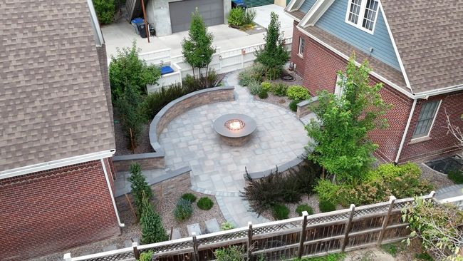 An aerial view of a backyard with a fire pit in the middle.