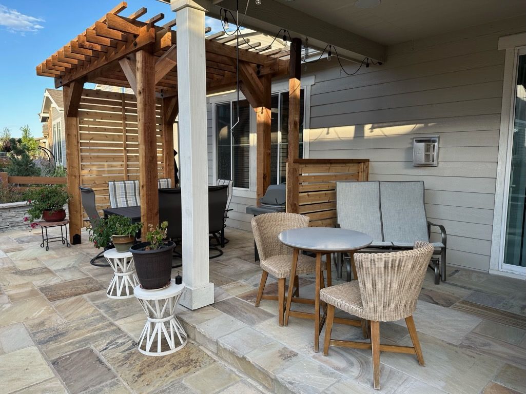 A patio with a table and chairs under a pergola.