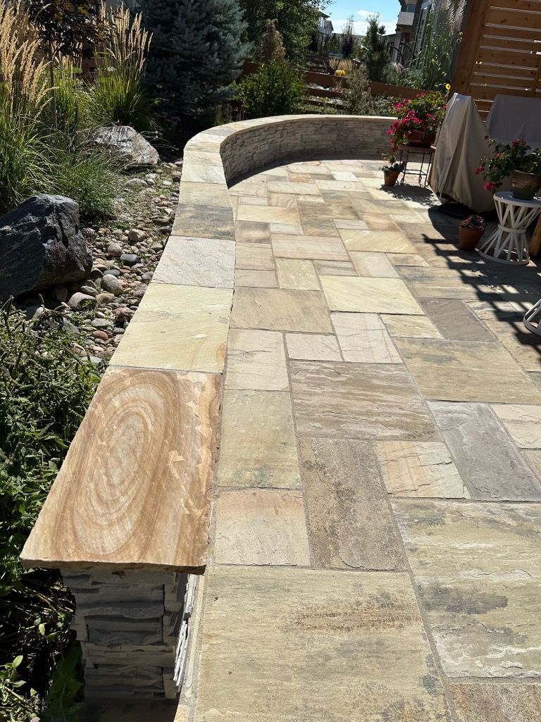 A stone walkway with a wooden bench on the side of it.