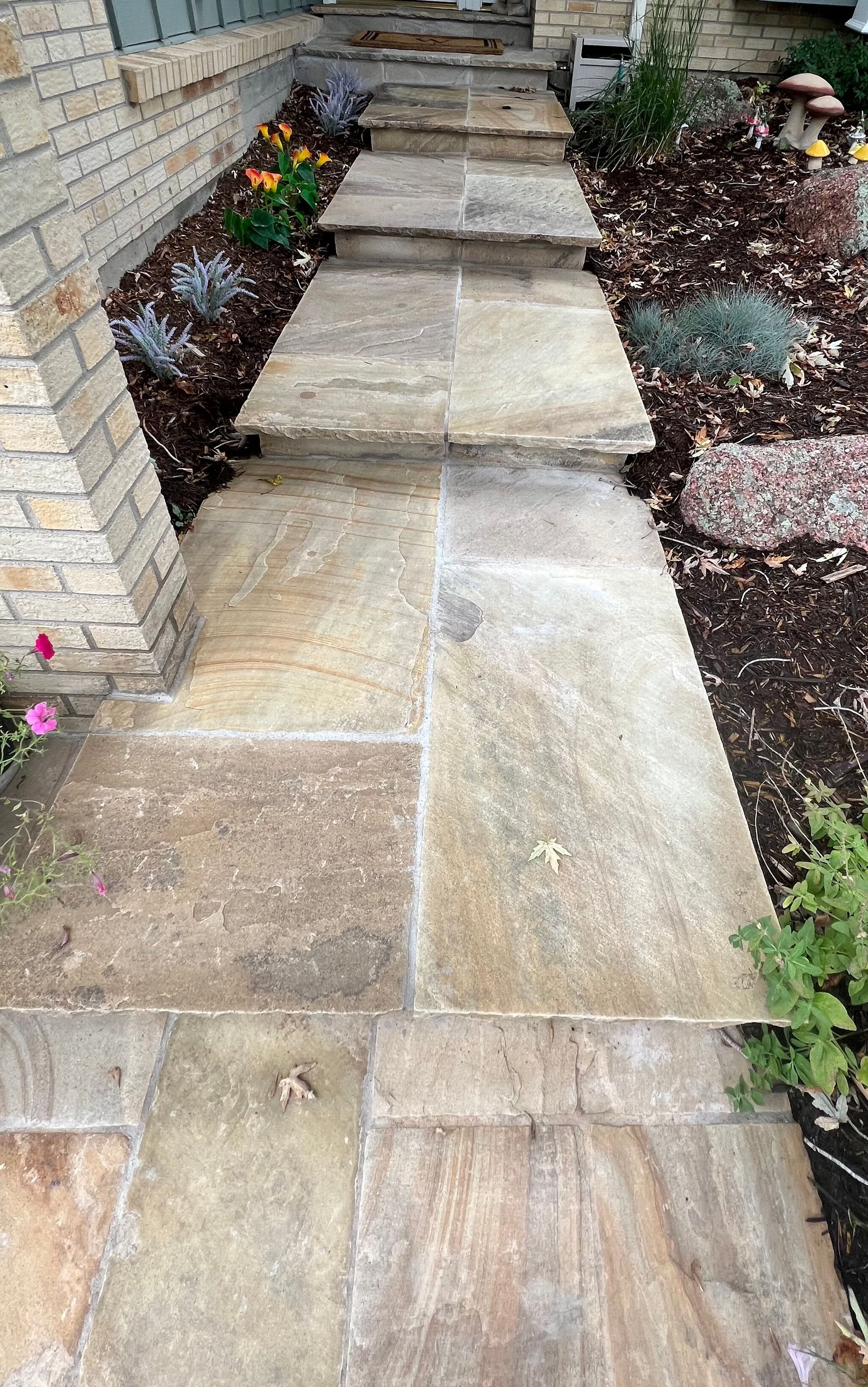 A stone walkway with steps leading up to a house.
