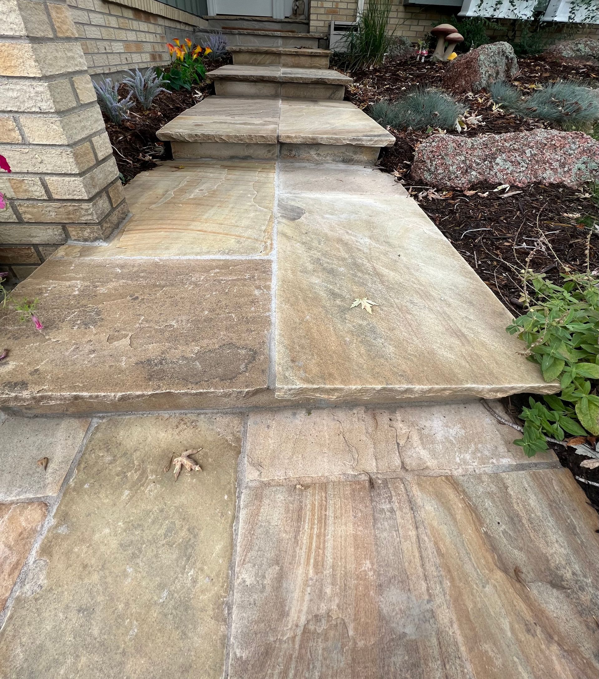 A stone walkway with stairs leading up to a house.