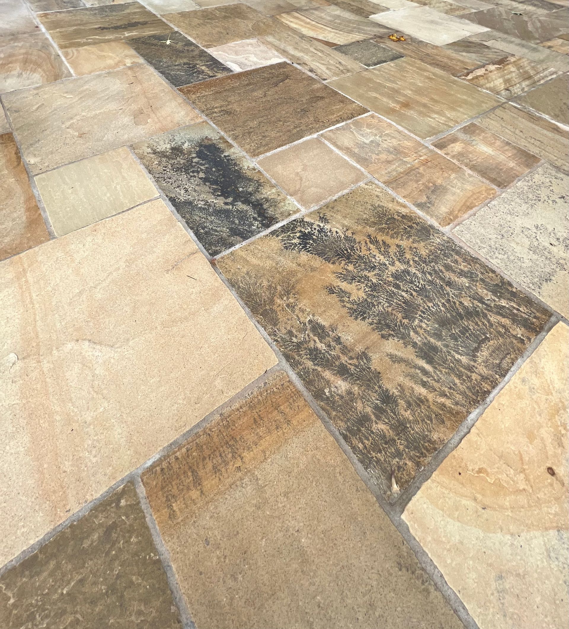 A close up of a tiled floor with different colored tiles.