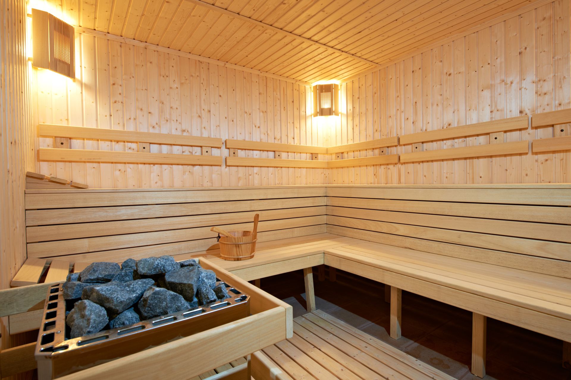 a wooden sauna with a lot of benches and rocks