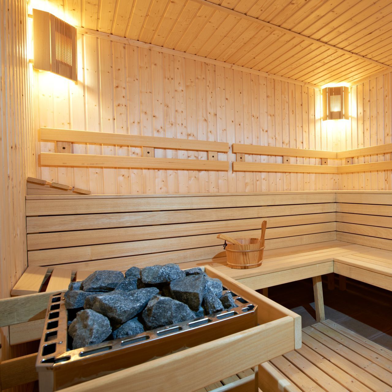 a wooden sauna with a bucket of rocks in it
