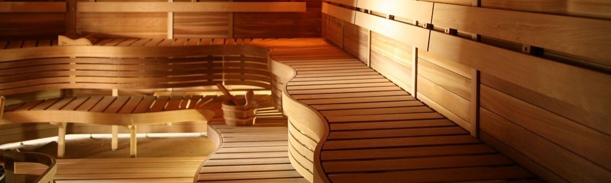 A wooden sauna with a lot of chairs and a table.