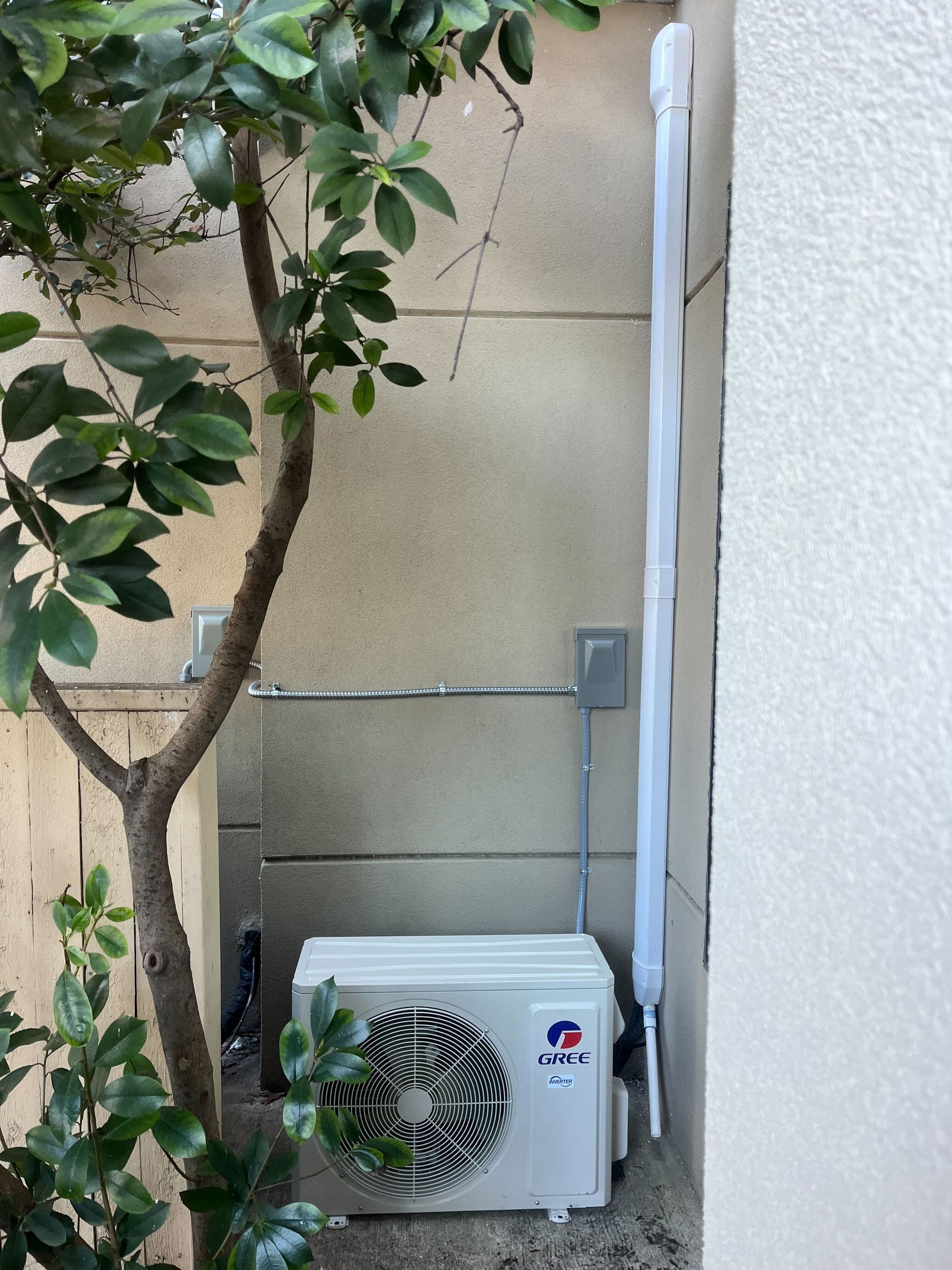 A gree air conditioner is mounted on the side of a building