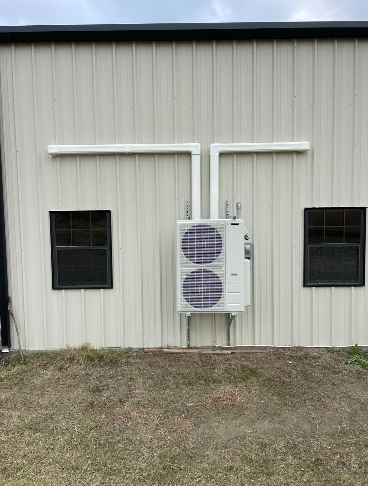 A large air conditioner is mounted on the side of a building.