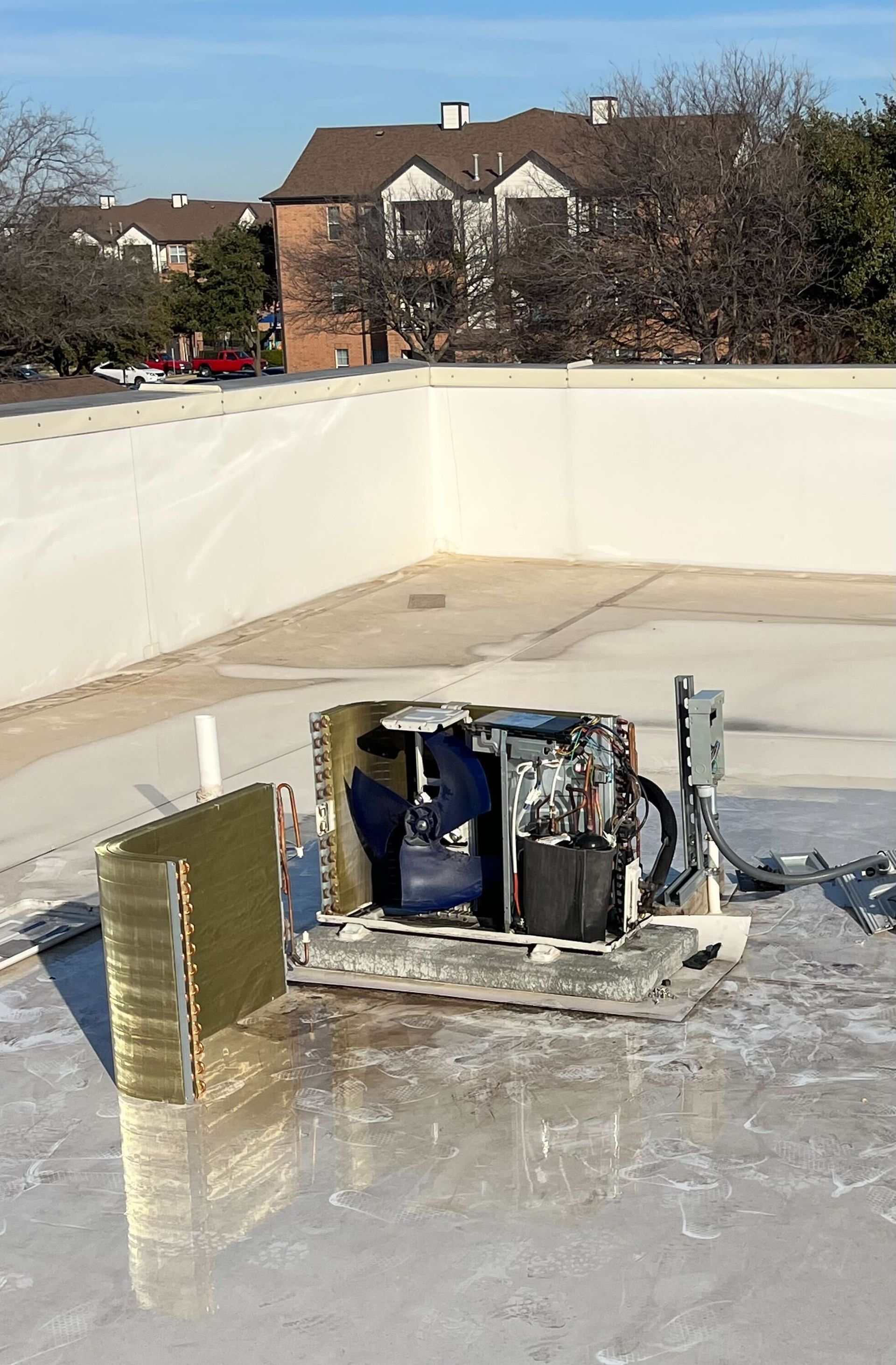A broken air conditioner is sitting on top of a roof.