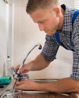 A man is fixing a faucet in a kitchen sink.