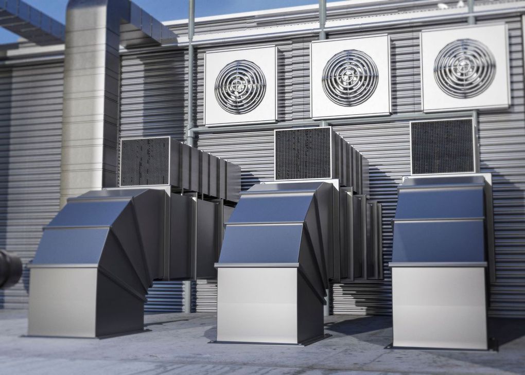 Rooftop HVAC system with large silver ventilation ducts and three wall-mounted industrial fans.