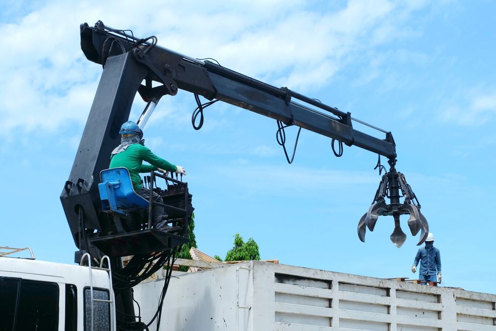 A Man is Driving a Truck With a Crane Attached to It — Alexander Crane Tippers in Queanbeyan, NSW