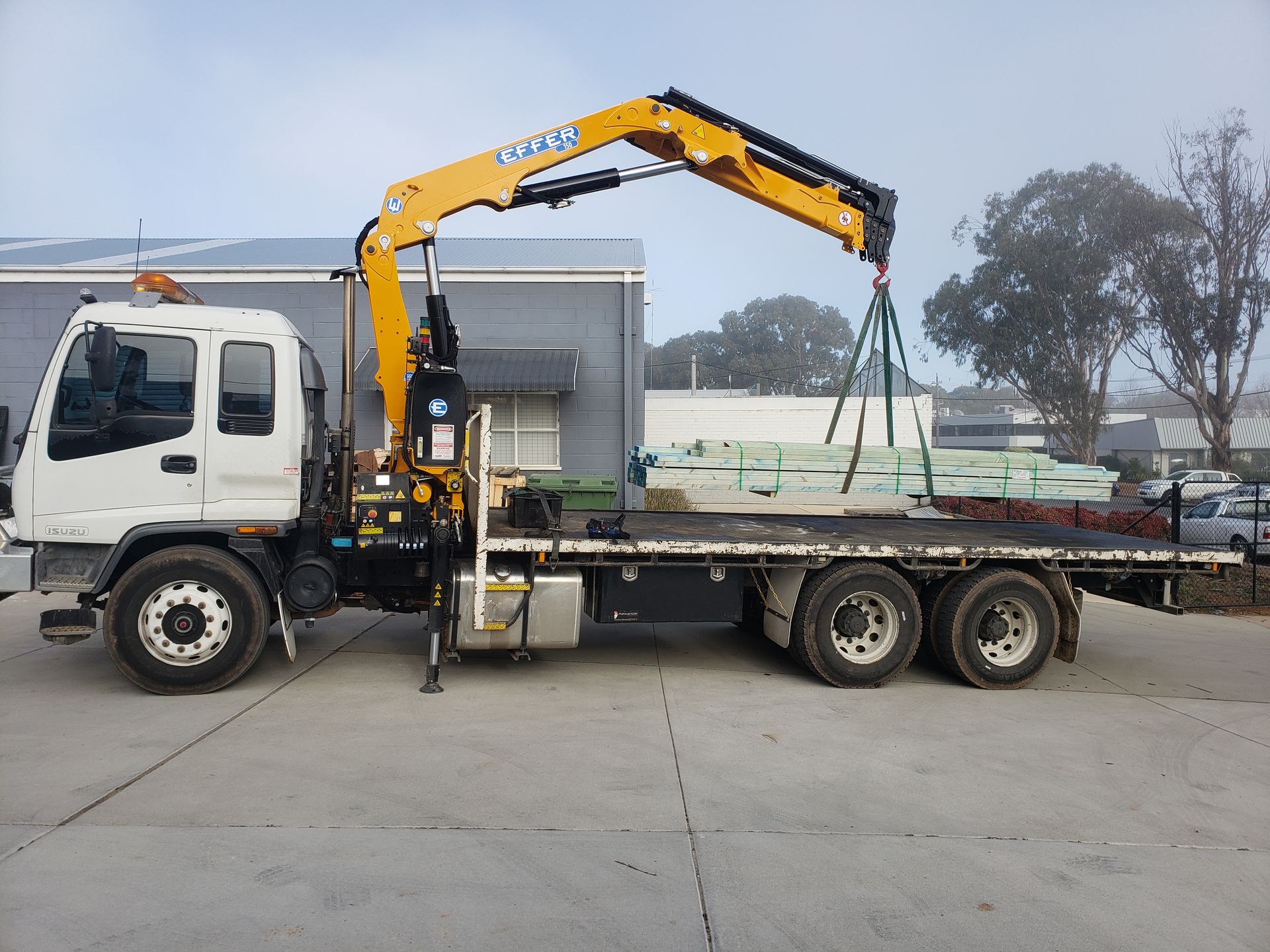A Flatbed Truck With a Crane Attached to It is Parked in a Parking Lot — Alexander Crane Tippers in Latham, ACT