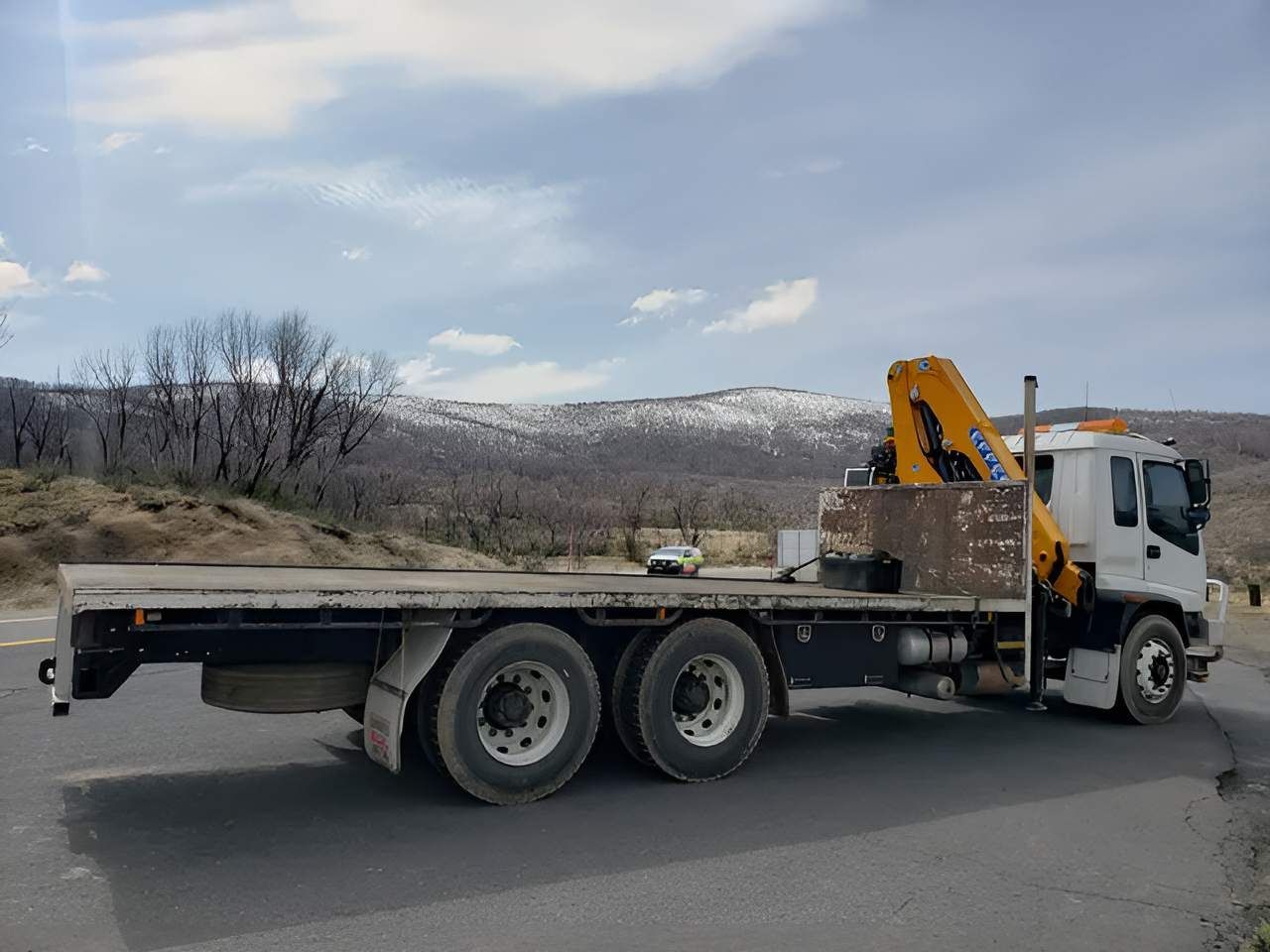 A Flatbed Tow Truck is Parked on the Side of the Road — Alexander Crane Tippers in Latham, ACT