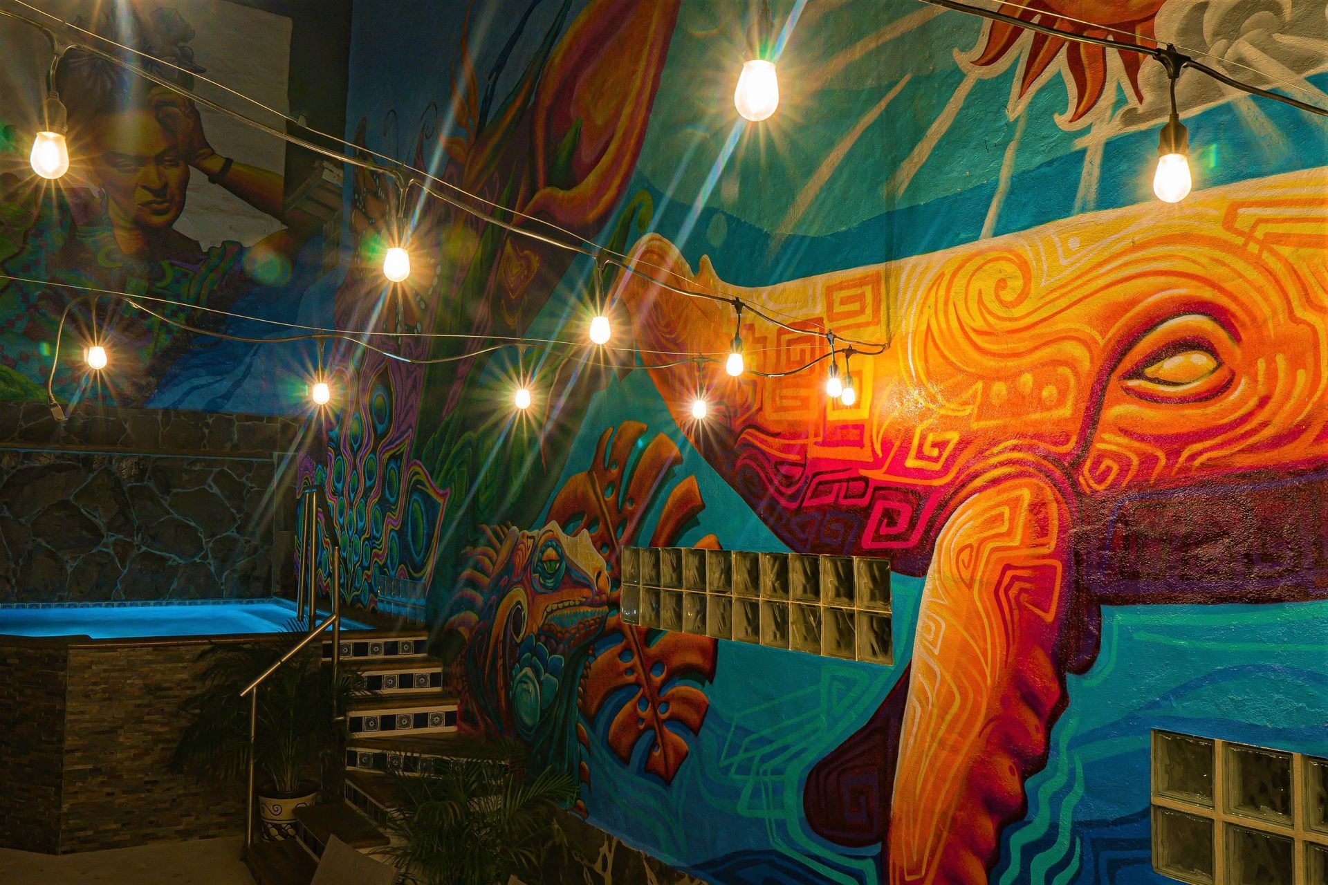 A mural on the side of a building next to a pool.