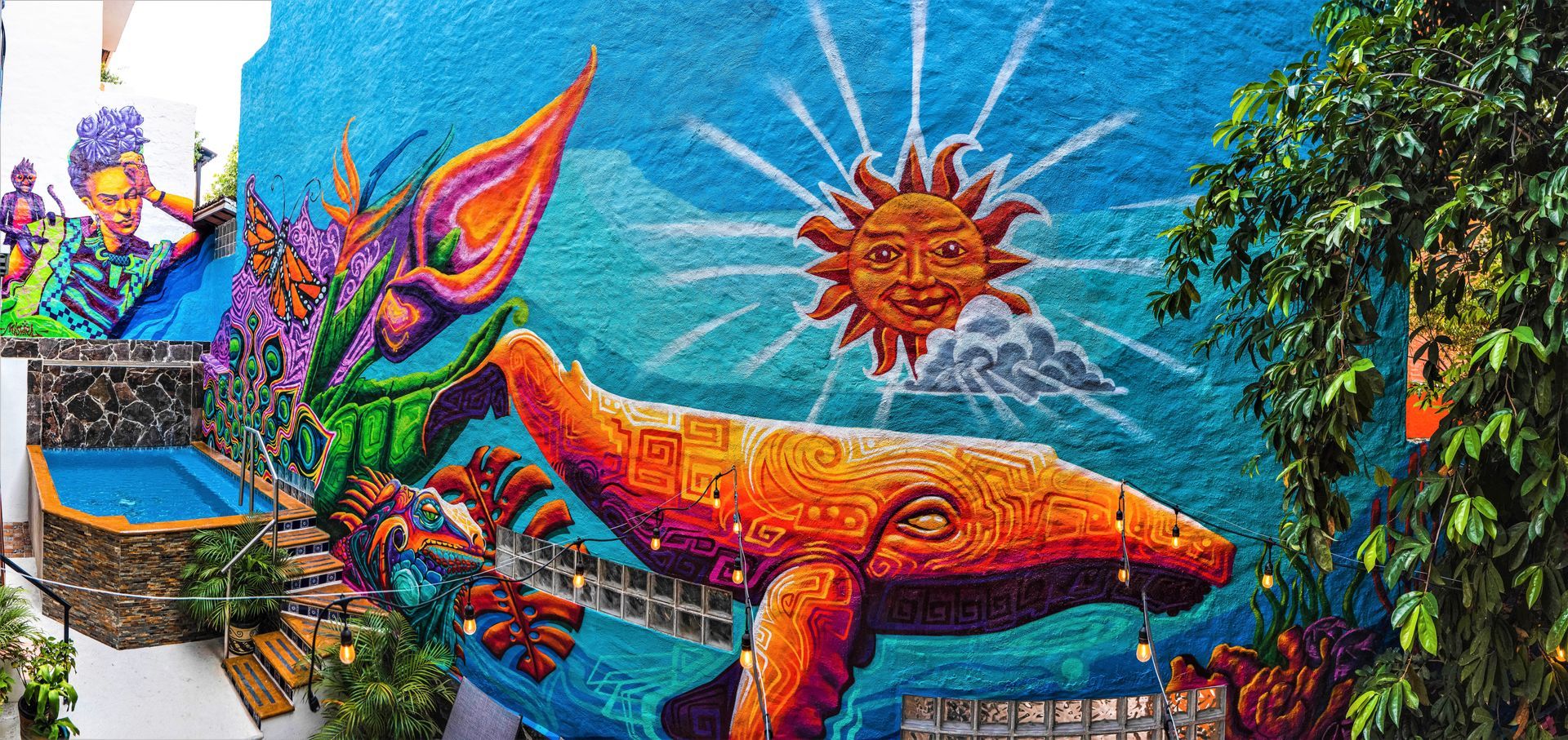 A colorful mural of a whale and a sun on a wall.