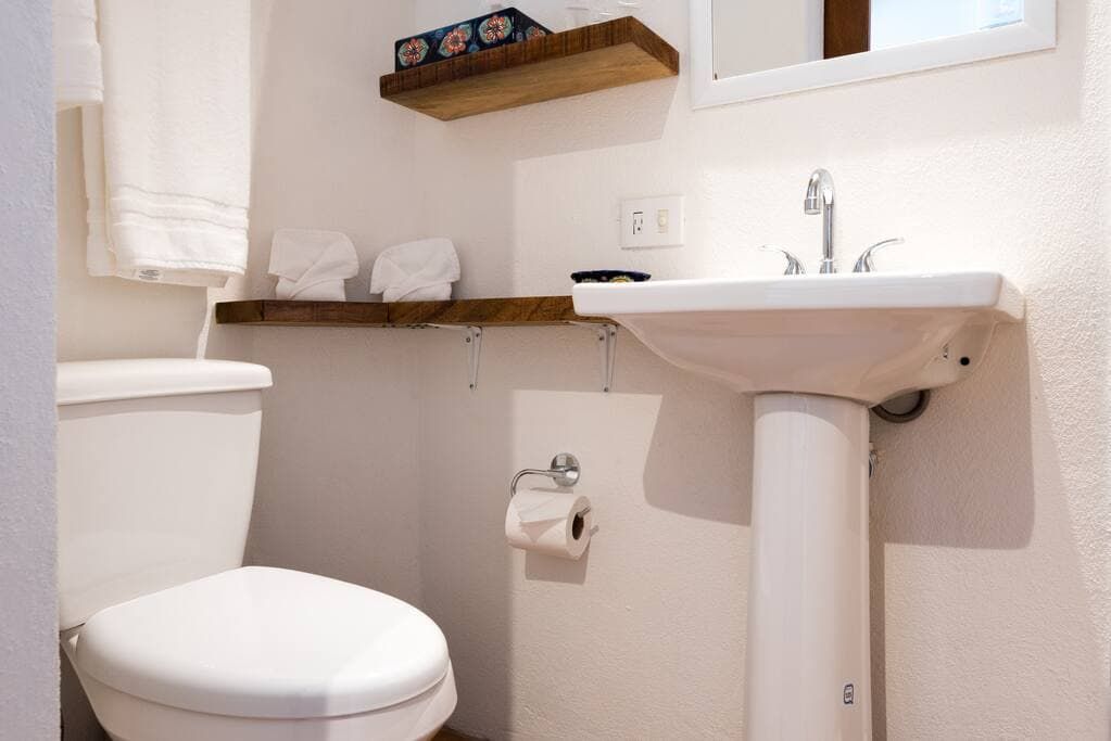 A bathroom with a toilet , sink and mirror