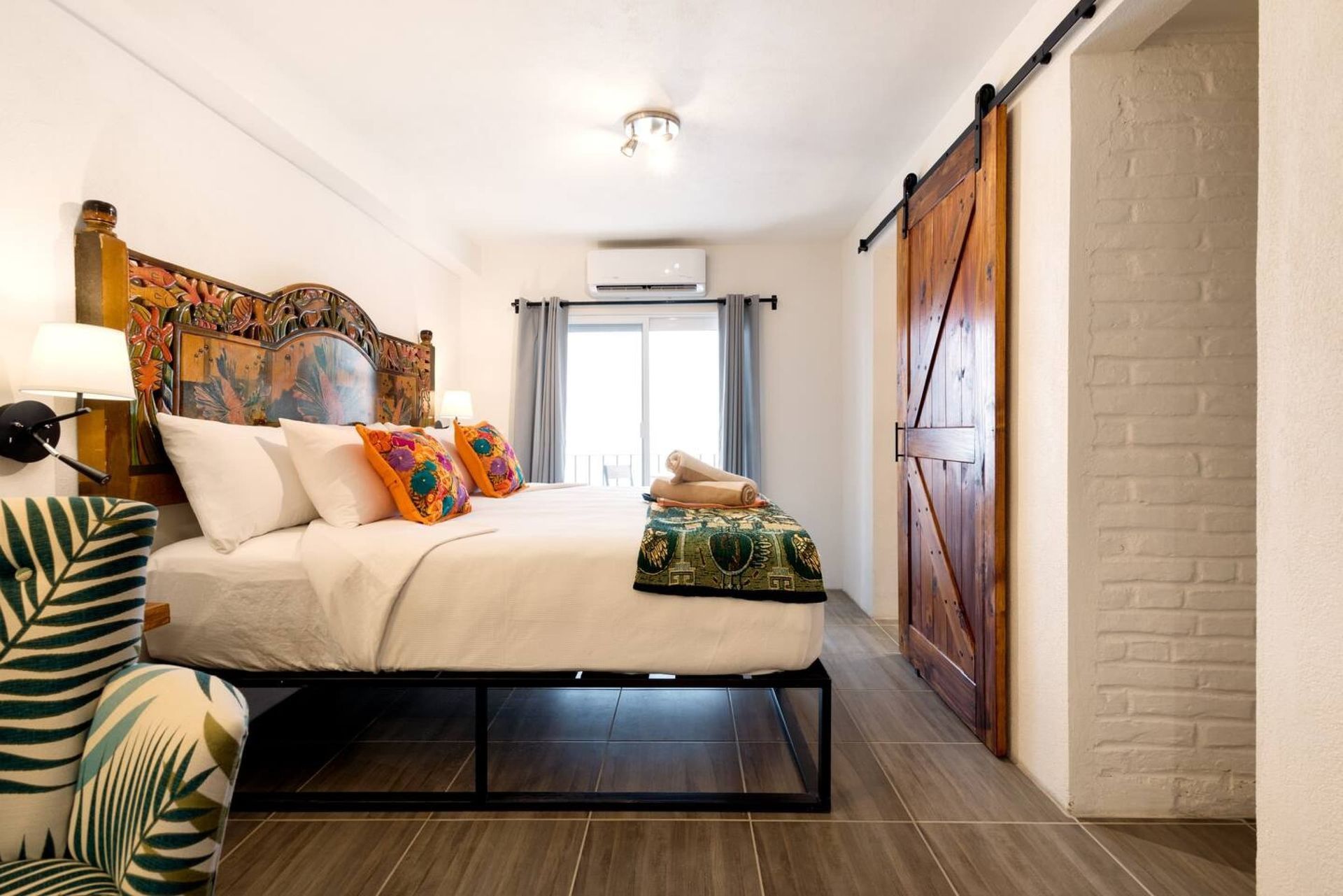 A bedroom with a king size bed and a sliding barn door.