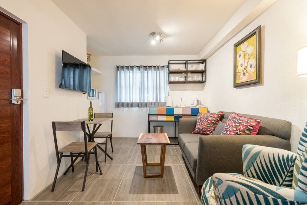 A living room with a couch , chairs , table and television.