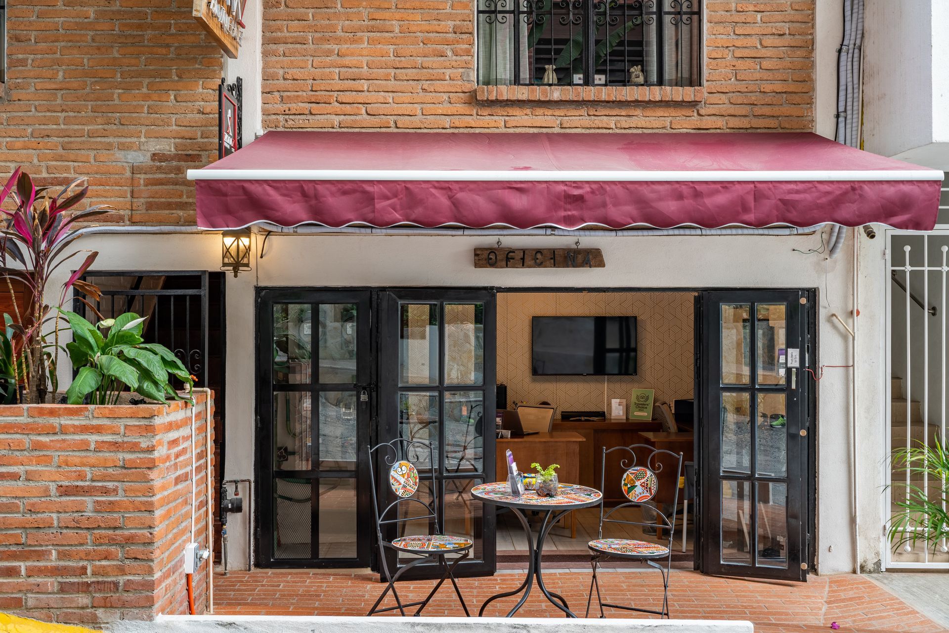 A brick building with a table and chairs under an awning.