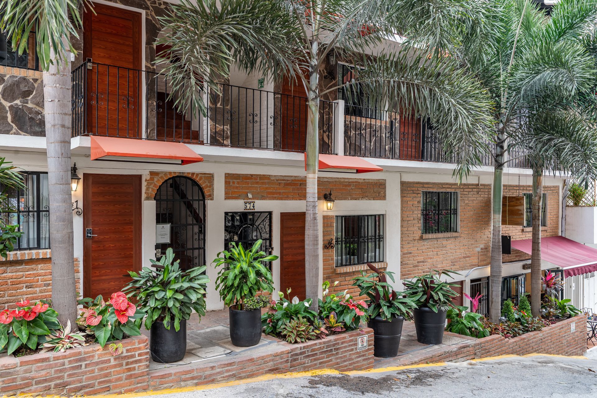 A building with a lot of potted plants in front of it.
