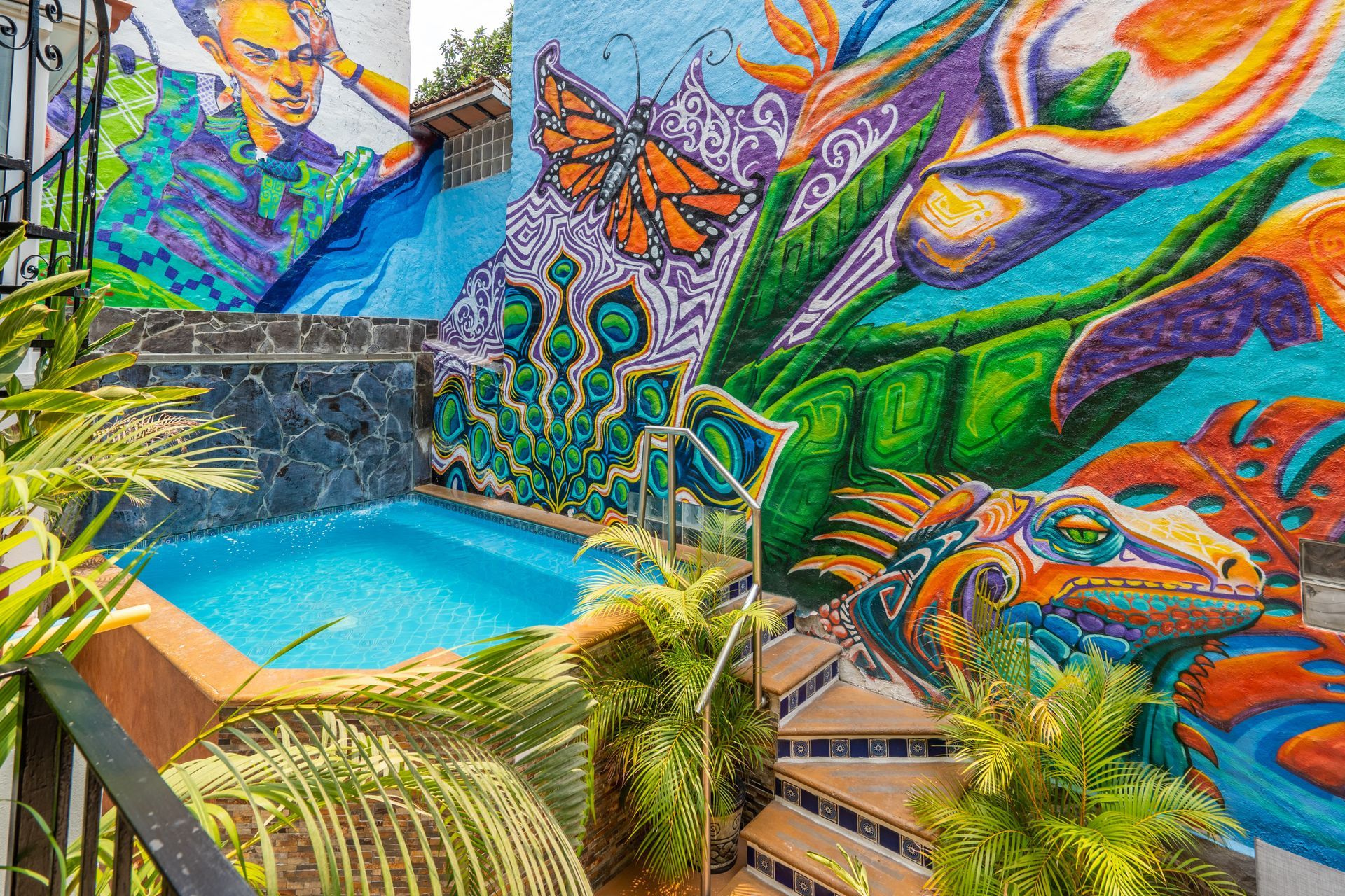 A swimming pool with a colorful mural on the side of a building.
