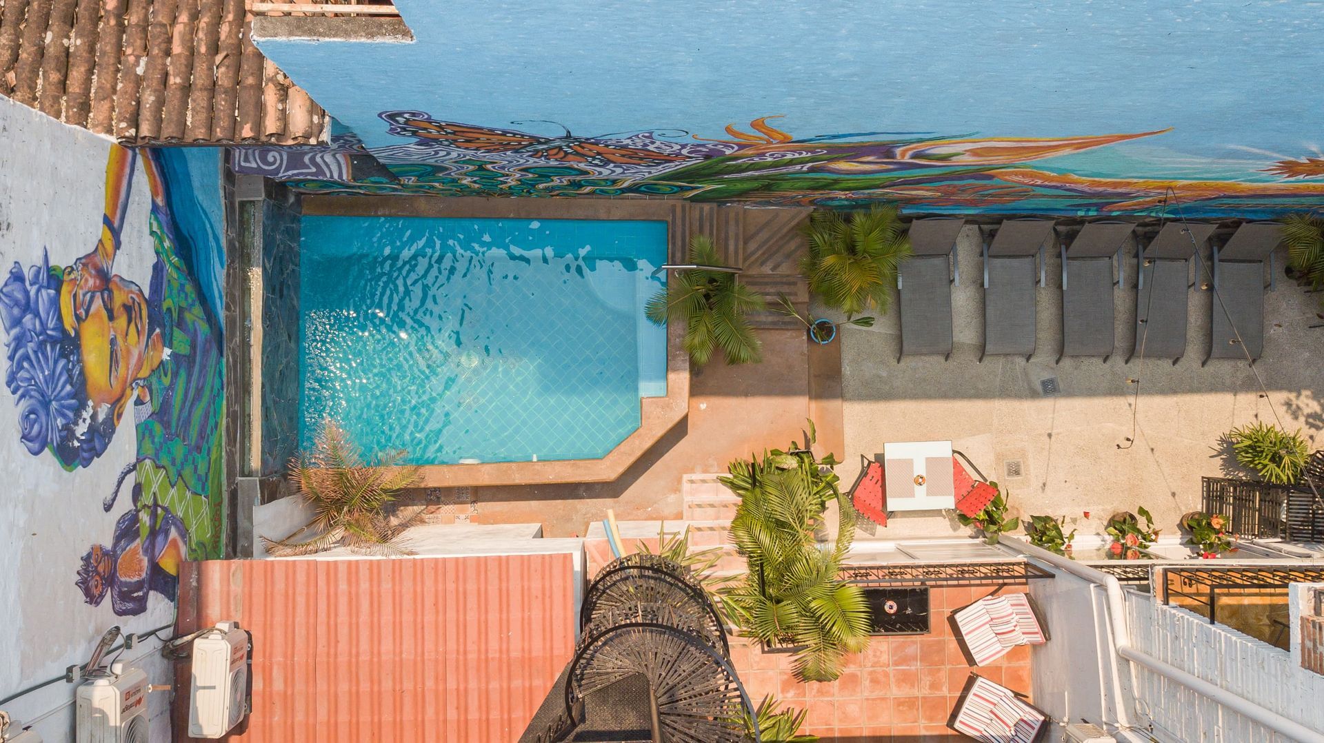 An aerial view of a swimming pool with a mural on the wall.