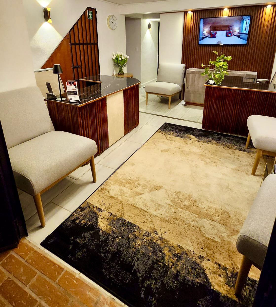Office reception area with a desk, chairs, and an abstract patterned rug.