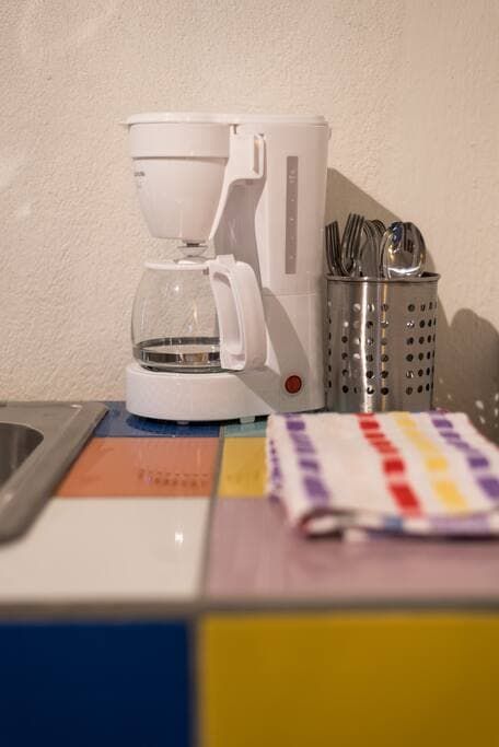 A coffee maker sits on a counter next to a towel