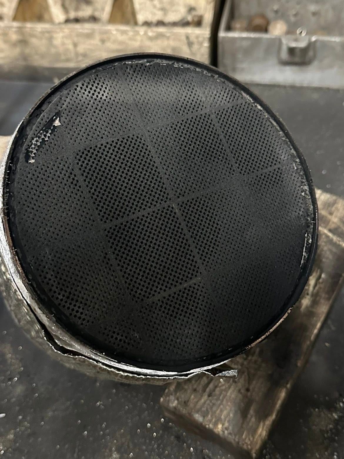 Primo piano di un convertitore catalitico nero danneggiato