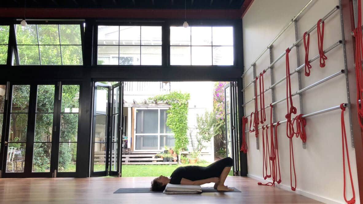 Female Doing Yoga Lying While Holding Feet — Marrickville, Sydney — Black Lotus Yoga