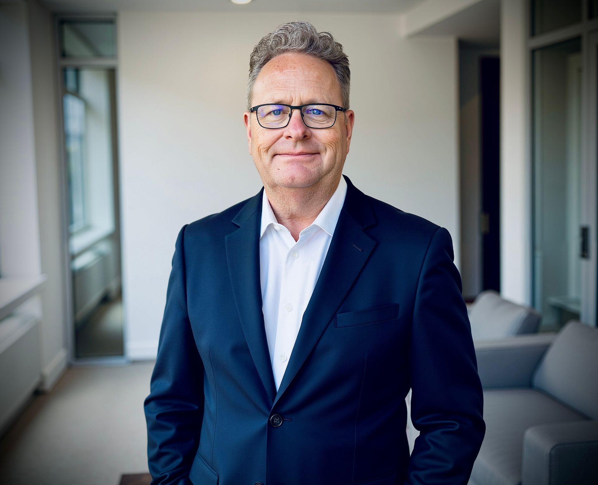 A man in a suit and tie is smiling for the camera