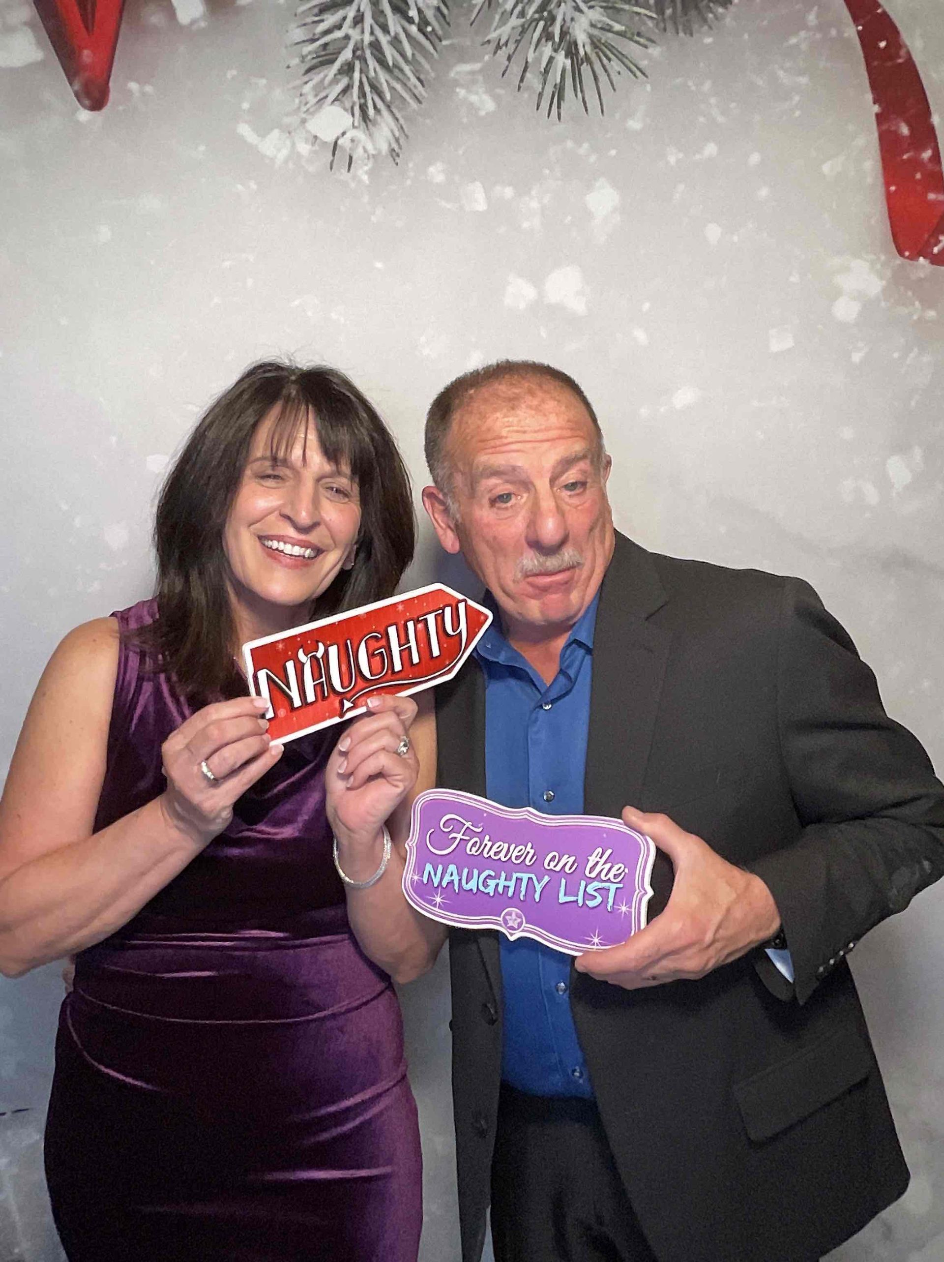 A man and a woman are posing for a picture in a photo booth.