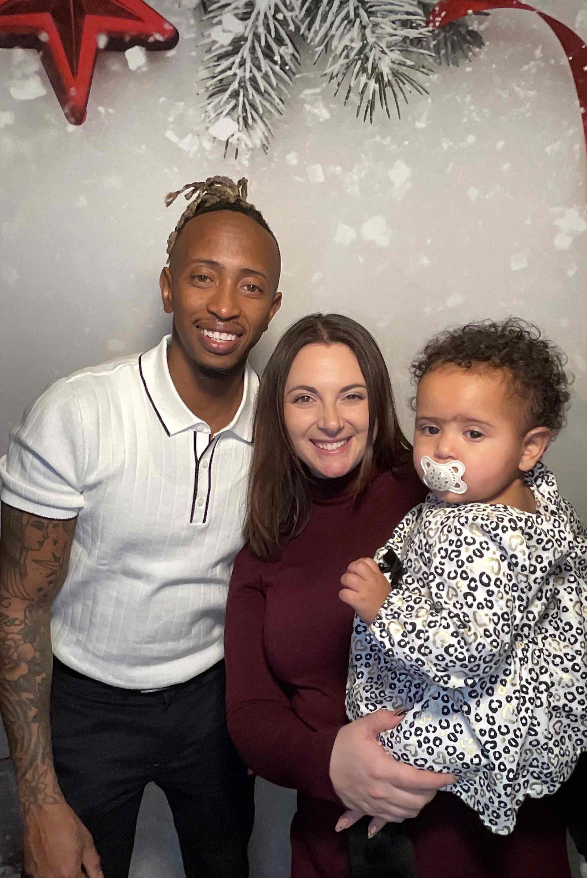 A man and a woman are holding a baby in their arms.