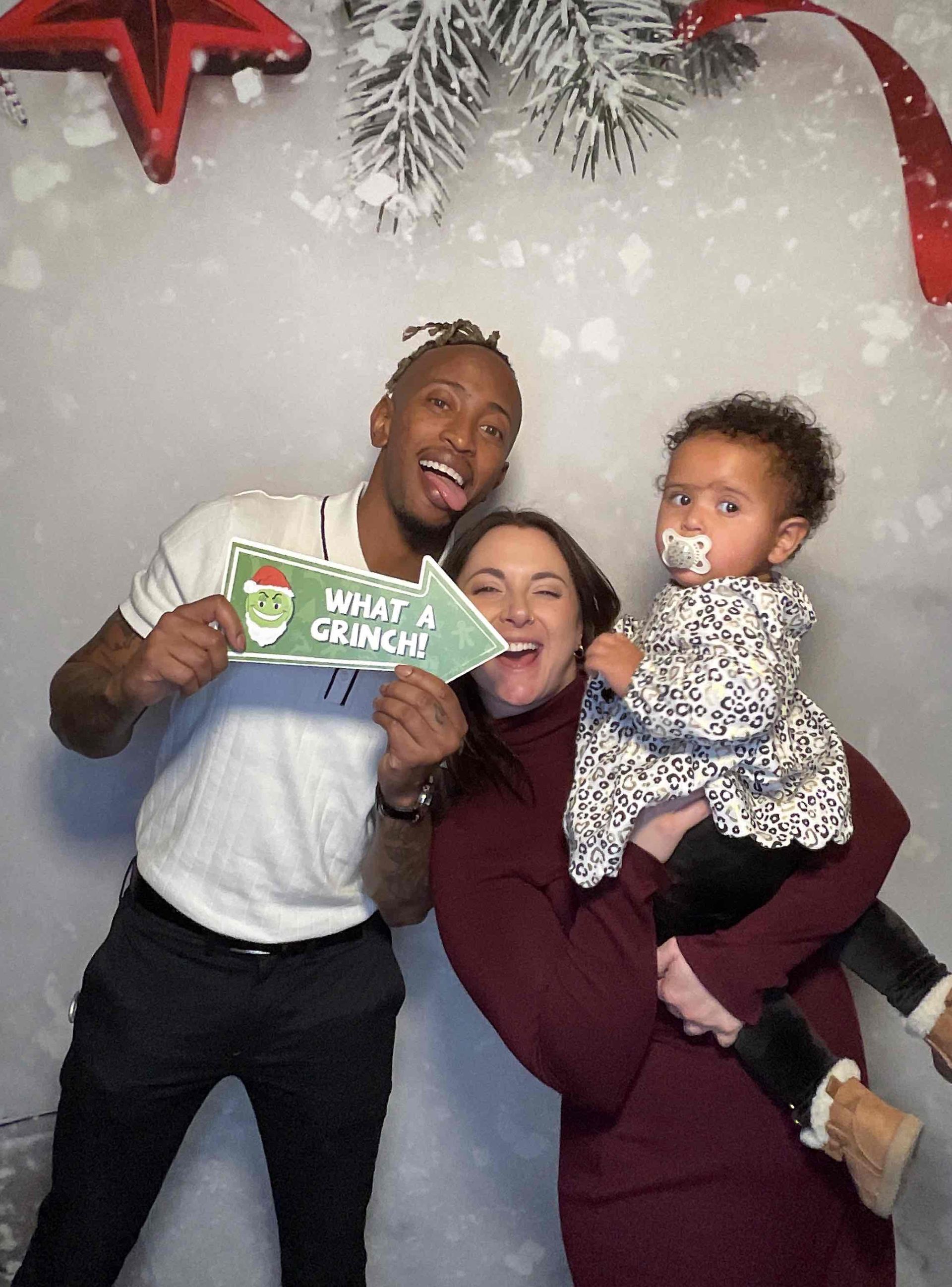 A man , woman and child are posing for a picture in a photo booth.