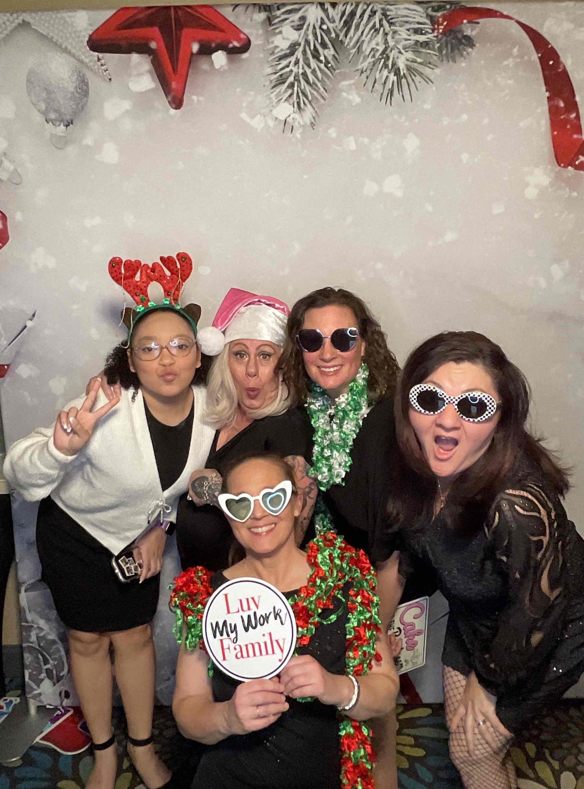 A group of women are posing for a picture in a photo booth.