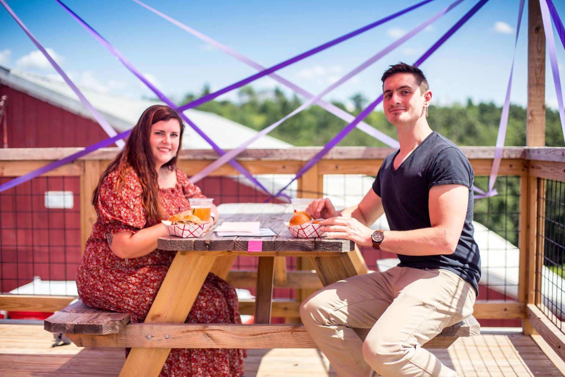 A man and a woman are sitting at a picnic table.