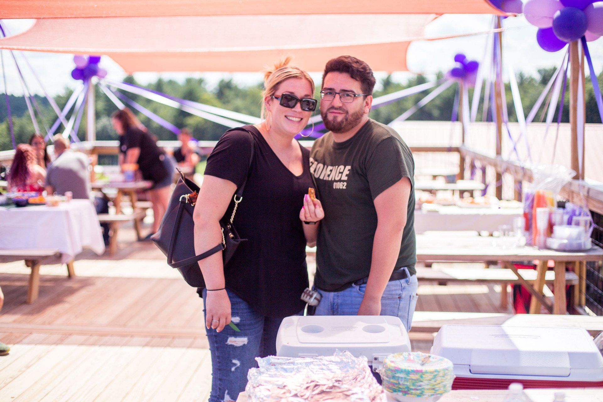 A man and a woman are standing next to each other in front of a cake.