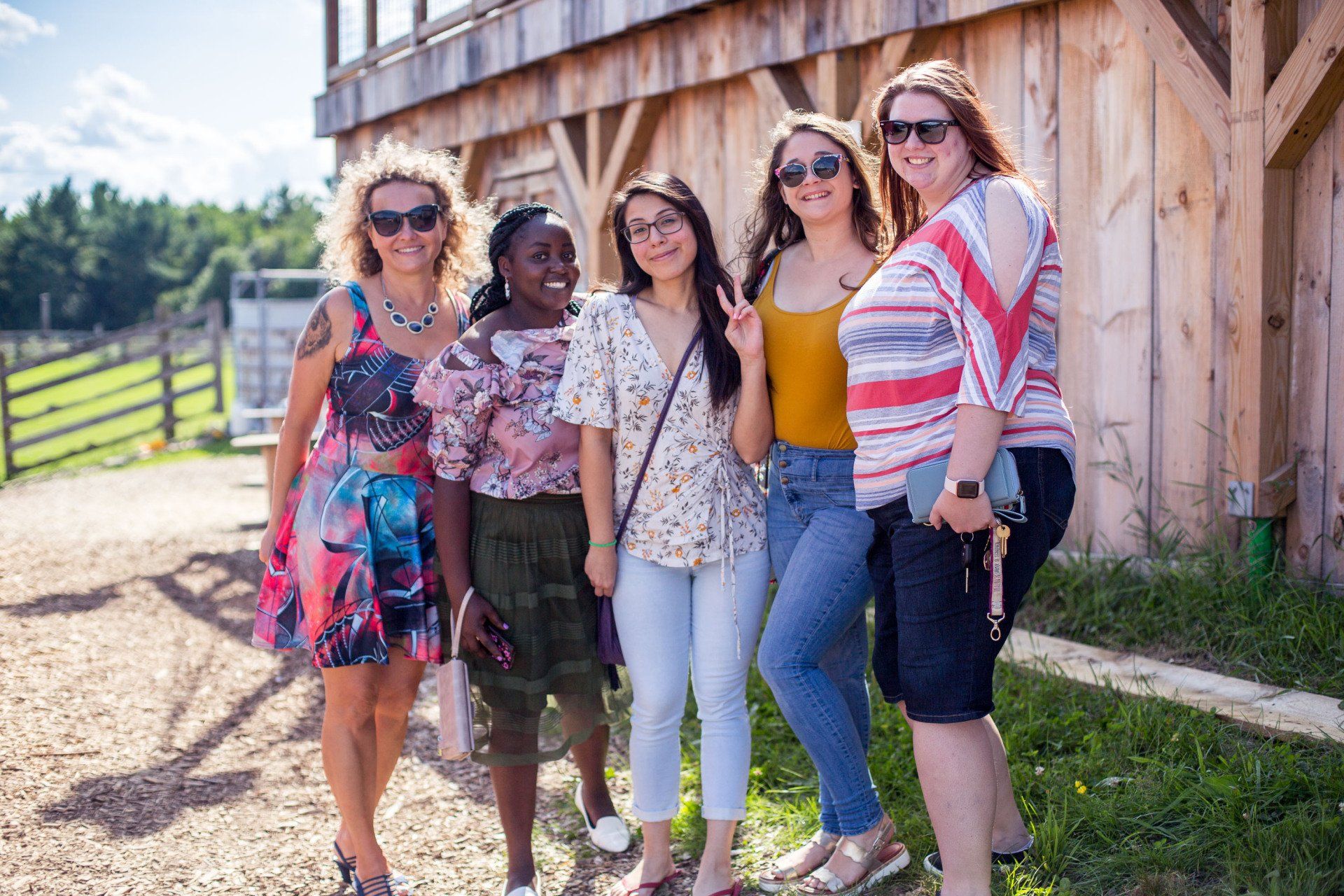 A group of women are posing for a picture in front of a wooden building.