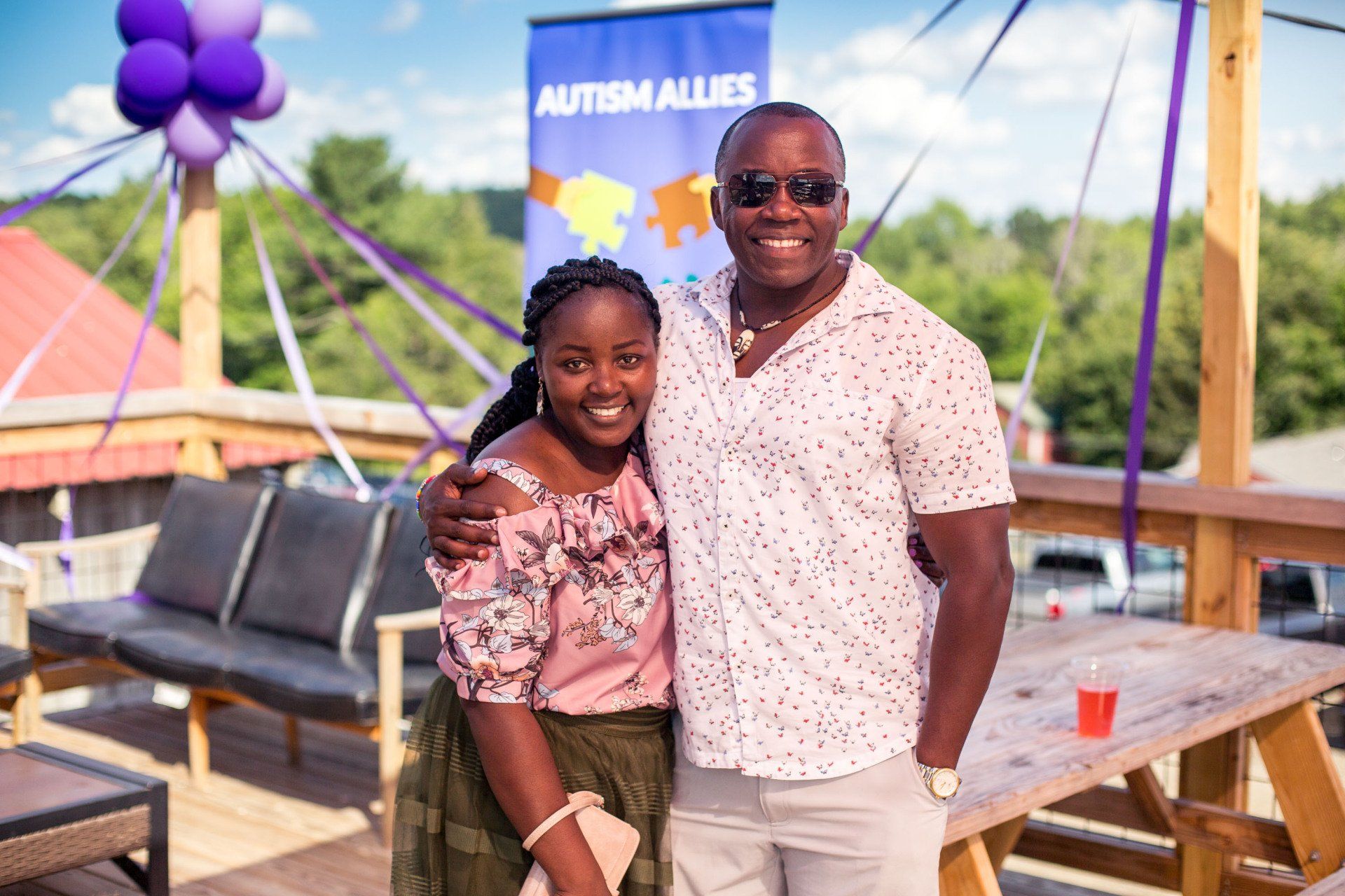A man and a woman are posing for a picture on a patio.
