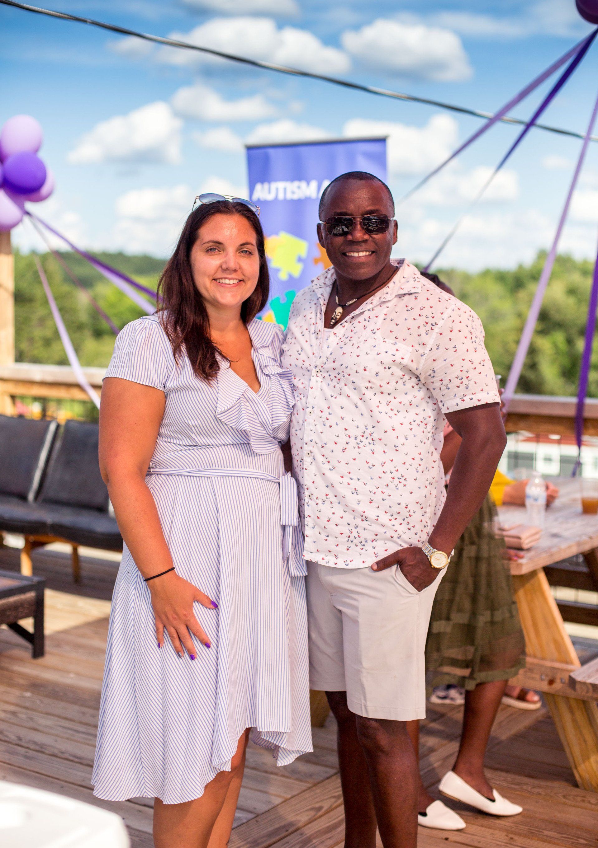 A man and a woman are standing next to each other on a wooden deck.