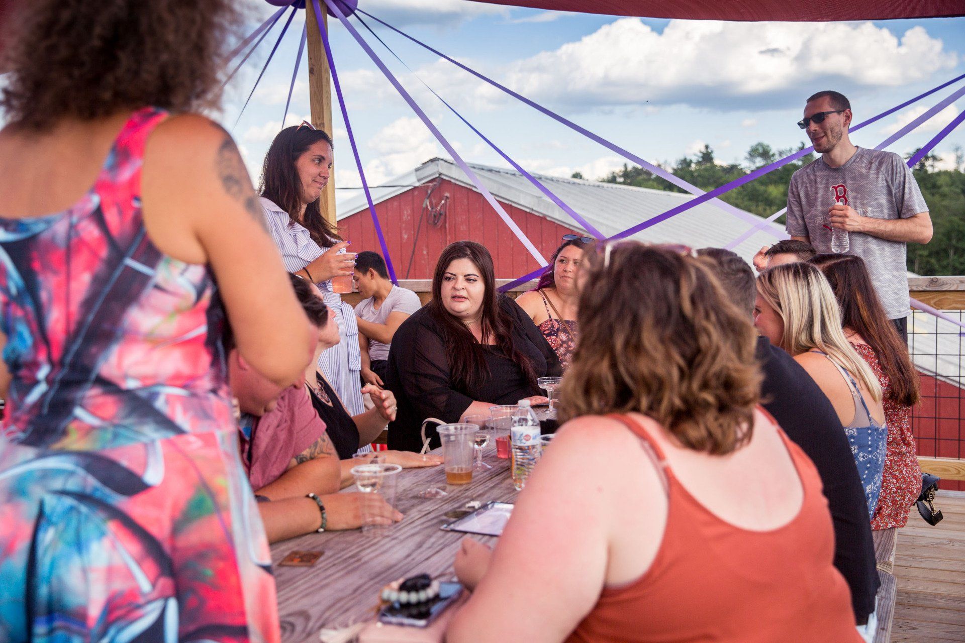 A group of people are sitting at a table under a tent.