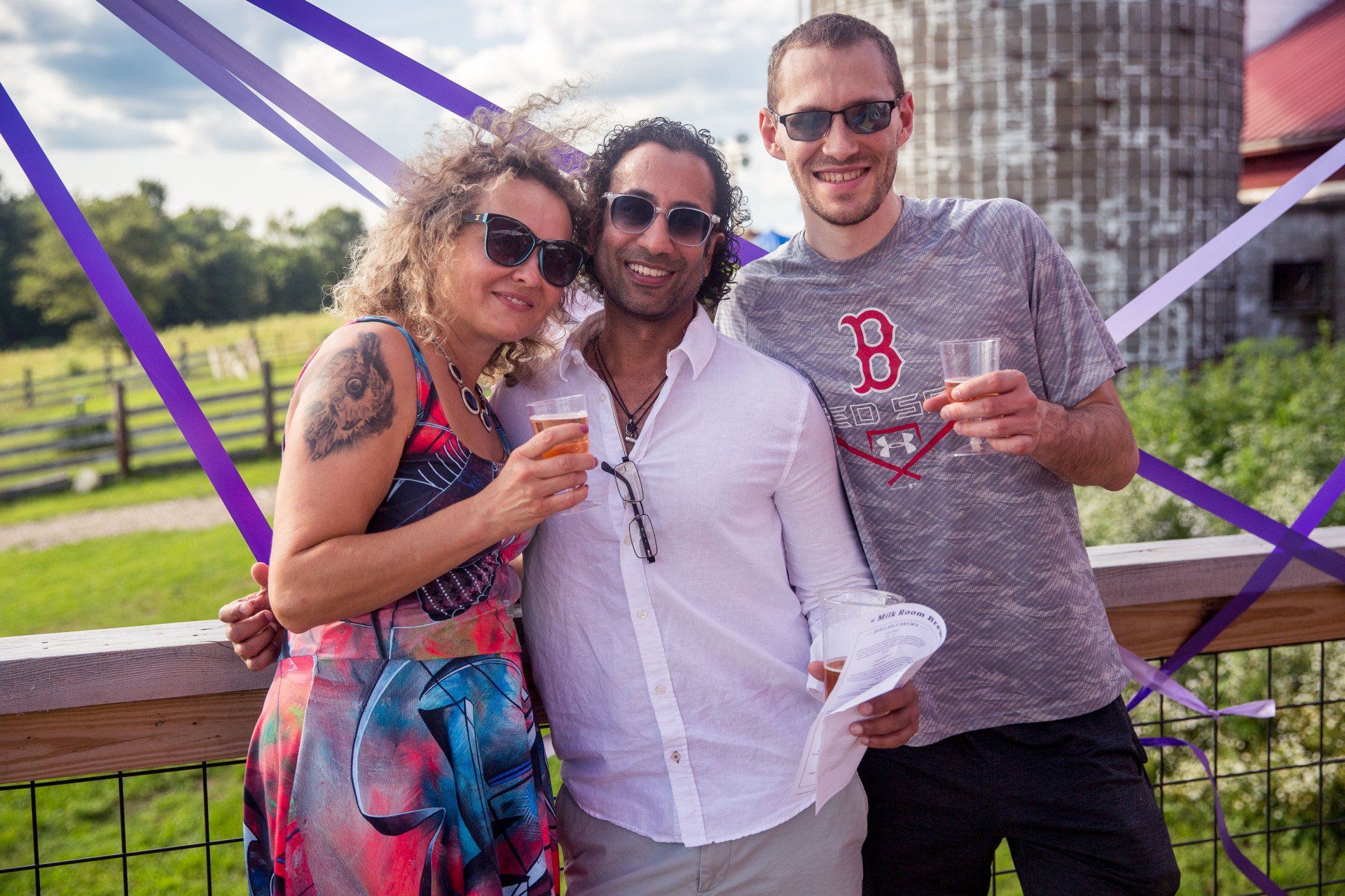 A group of people are posing for a picture while holding drinks.
