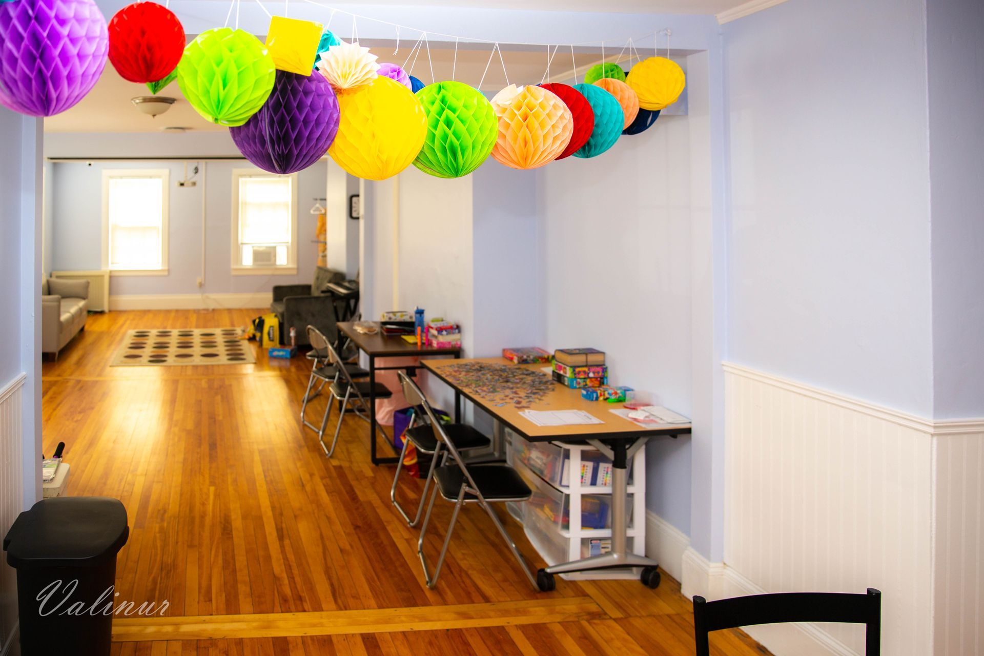 A room with a lot of colorful paper lanterns hanging from the ceiling