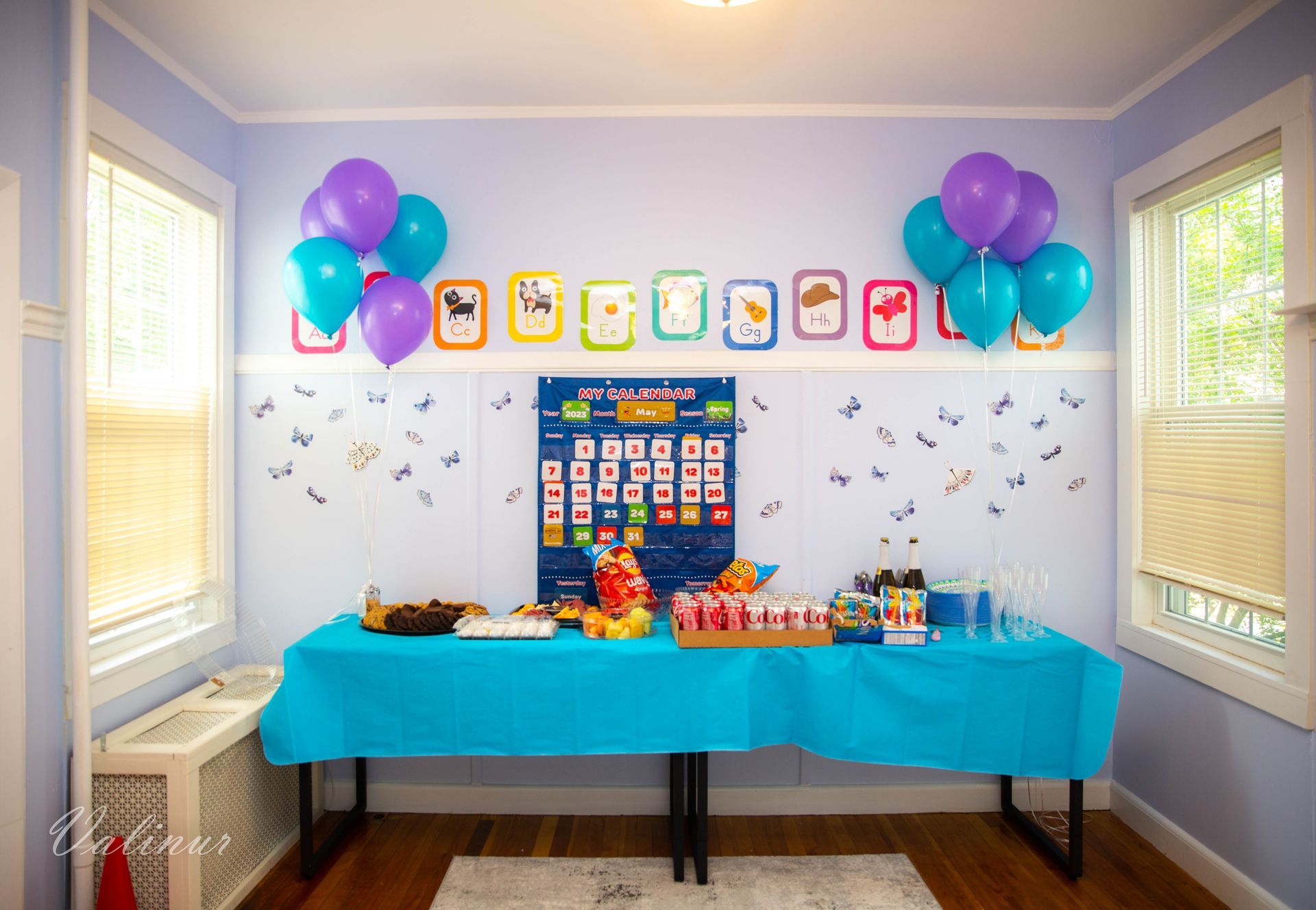 A room with a table and balloons on the wall