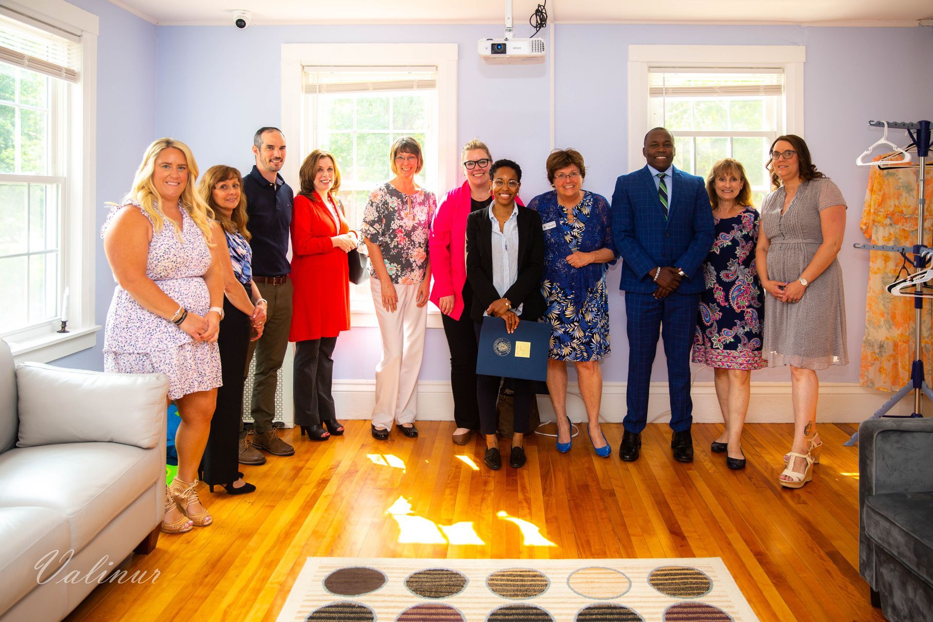 A group of people are posing for a picture in a living room.
