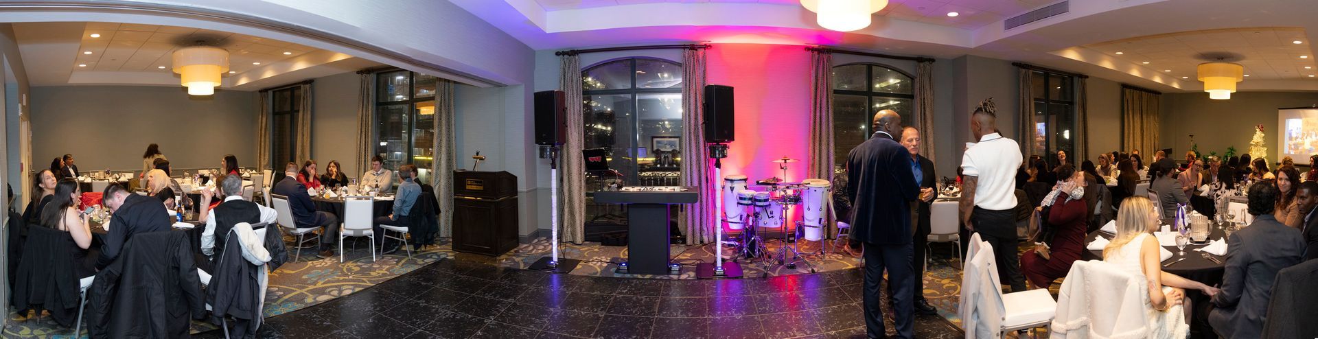 A large group of people are sitting at tables in a large room.