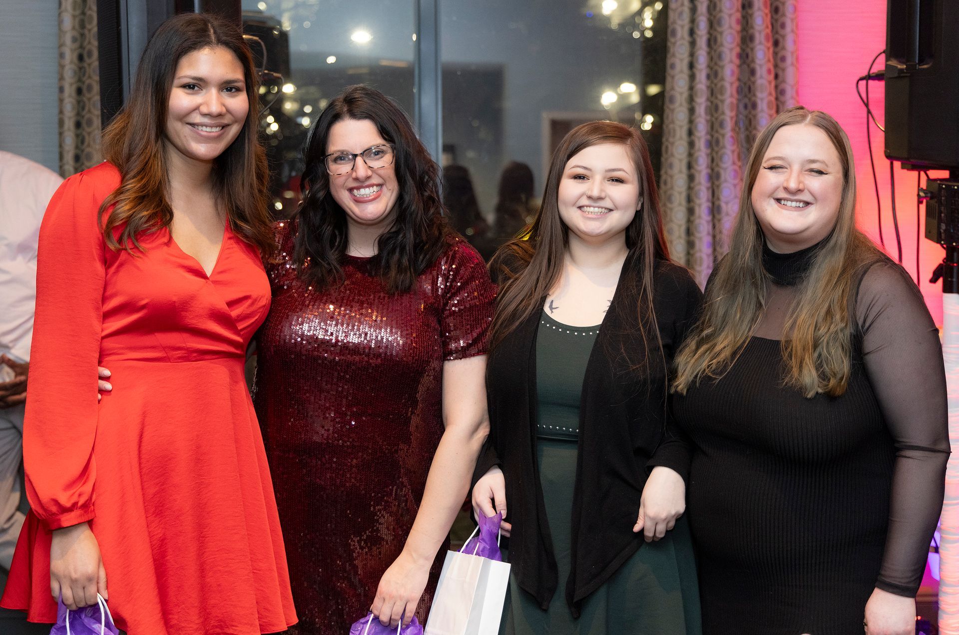 A group of women are posing for a picture together at a party.