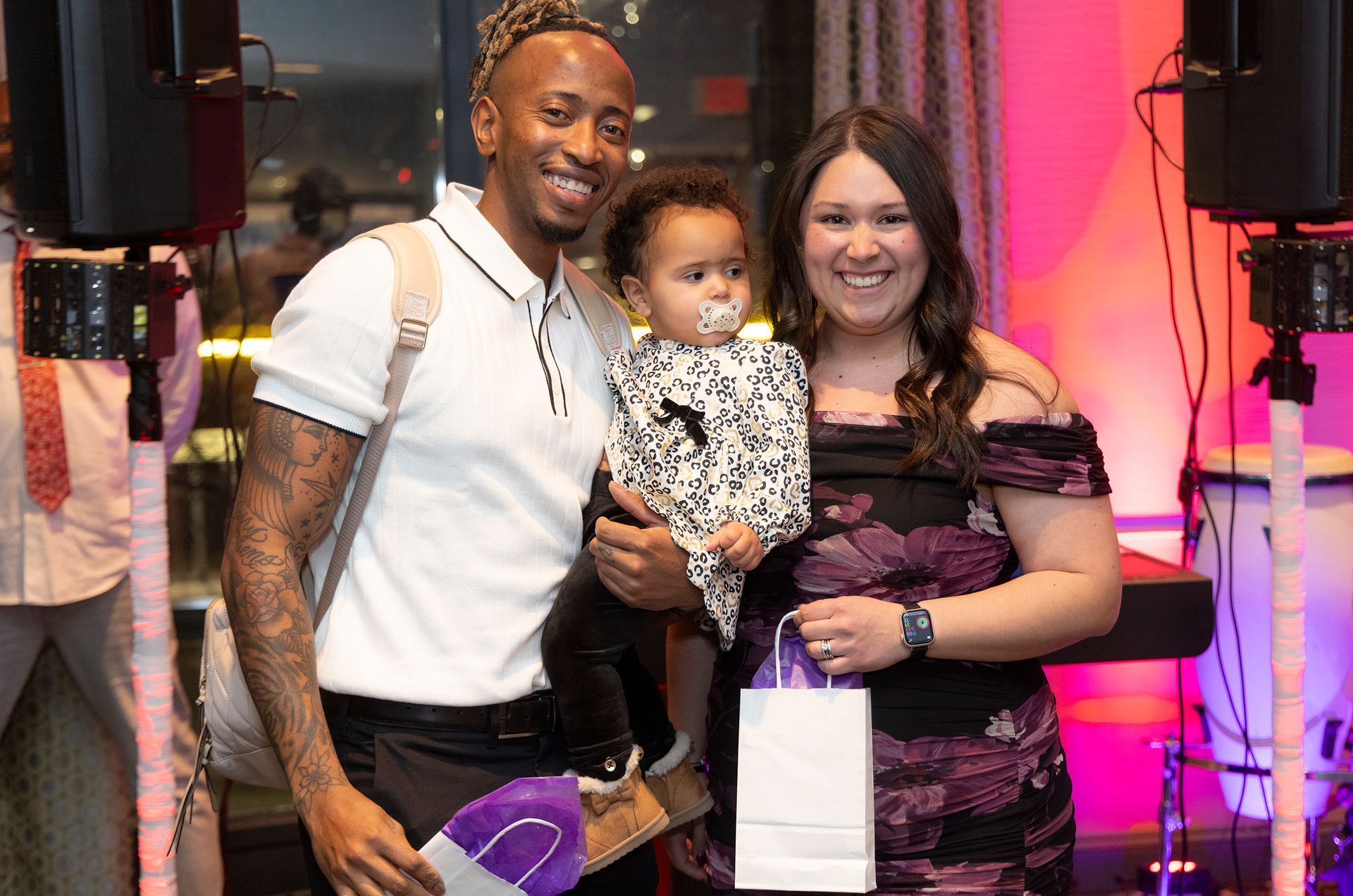 A man and woman are holding a baby and posing for a picture.