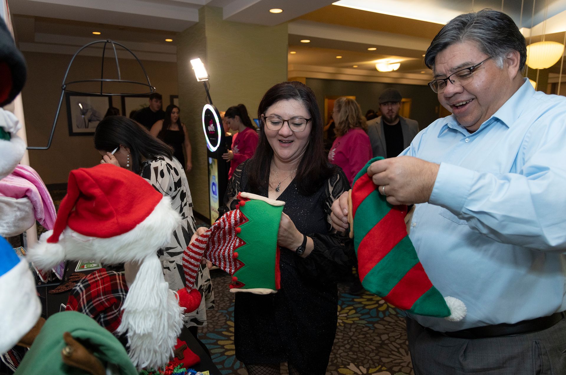 A man and a woman are holding christmas stockings in a room.